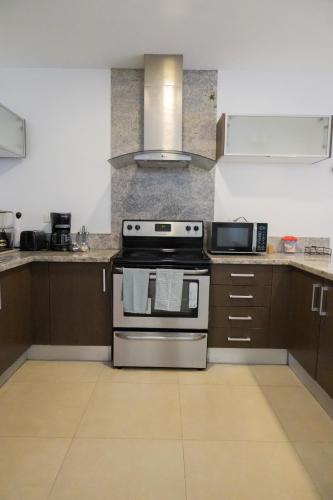 a kitchen with a stove and a microwave at Ka' Romana Residences in El Soco