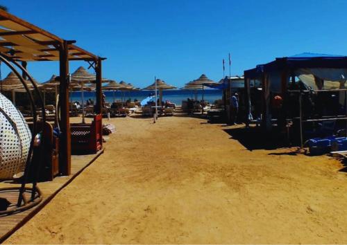 a beach with umbrellas and chairs on the sand at Luxury Sharm Hills Resort in Sharm El Sheikh