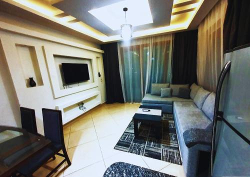a living room with a couch and a tv at Luxury Sharm Hills Resort in Sharm El Sheikh