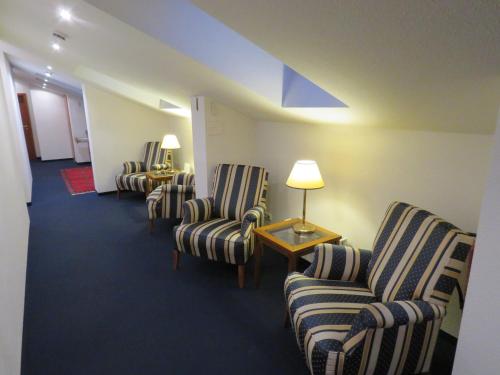 a waiting room with chairs and a table with a lamp at Pension Freiraum Guesthouse Berlin in Berlin