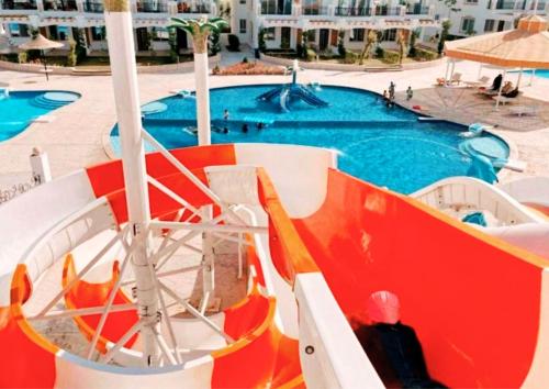 a person sitting on a slide next to a swimming pool at Luxury Sharm Hills Resort in Sharm El Sheikh