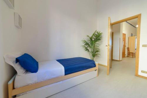 une chambre avec un lit avec des draps bleus et une plante dans l'établissement Alla torre, à San Vincenzo