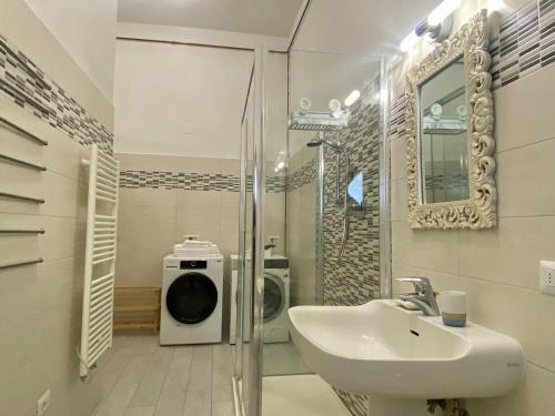 une salle de bain avec un lavabo et une machine à laver dans l'établissement Alla torre, à San Vincenzo