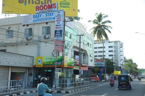 a man riding a motorcycle down a busy city street at Easy Stay Eranhipalam in Kozhikode