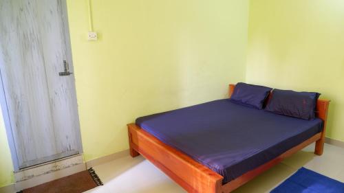 a small bed in a room with a window at Easy Stay Eranhipalam in Kozhikode