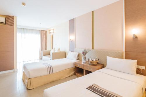 a hotel room with two beds and a window at Clef Hotel Bangkok in Bangna