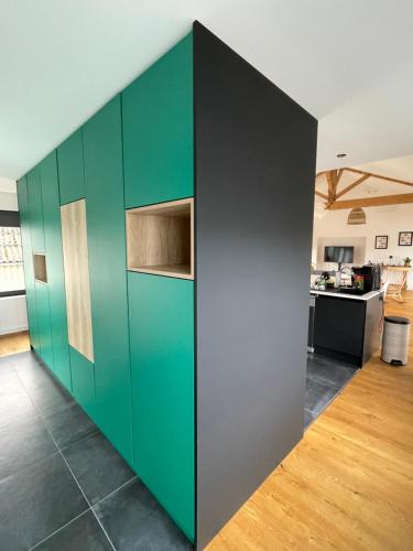 une armoire verte et grise dans une pièce avec une cuisine dans l'établissement Appartement loft avec terrasse, à Châteaubriant