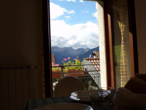 a table with a view of the mountains from a window at Nido d'Aquila in Schilpario