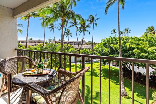 un tavolo e sedie su un balcone con palme di Kihei Akahi D205 a Wailea