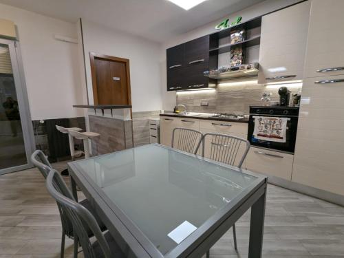 a kitchen with a glass table and chairs at La casa di Jo in Navacchio