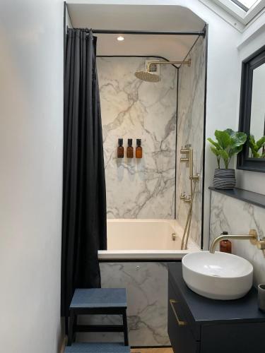 a bathroom with a shower with a tub and a sink at Cheerful 2 bed house on Causeway Coastal Route with parking in Whiteabbey