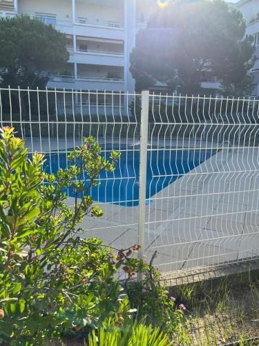 une clôture en face d'une piscine dans l'établissement Appartement T2, 55M2, meublé, piscine, à Marseille