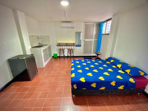 a bedroom with a bed with a blue blanket with yellow butterflies at Apartamento cerca a la playa y al centro historico in Santa Marta