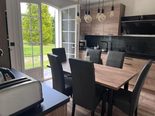 une salle à manger avec une table et des chaises en bois dans l'établissement La perle normande, à Sainte-Opportune-la-Mare