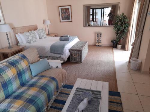 a living room with a bed and a couch at Barnard Self Catering Apartments in St Francis Bay