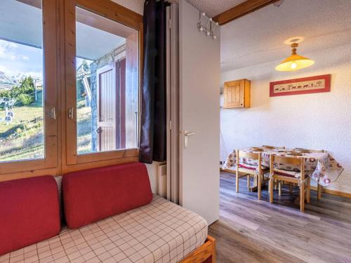 un salon avec une table et un canapé rouge dans l'établissement Studio divisible 4 pers, cuisine équipée, proche pistes - FR-1-353-77, à La Plagne