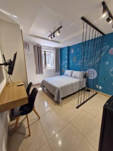 a bedroom with a bed and a desk and a computer at Studio Orion in Rio de Janeiro