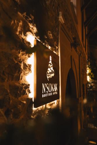 a sign on the side of a building at night at N'SOKAK Boutique Hotel in Gjirokastër