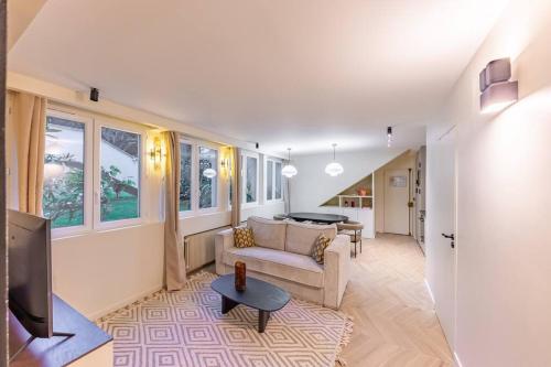 un salon avec un canapé et une télévision dans l'établissement NEW Spacious 4 Star Family Apartment in Chic 16th District, à Paris