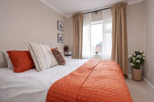 Un dormitorio con una cama grande con una manta naranja. en Three Bedroom House by Brookland Stays Serviced Accommodation Short Lets Manchester with Free WiFi, en Mánchester