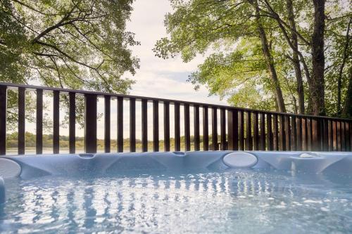 a hot tub with a fence and trees at Chiffchaff Lodge with Hot tub in Carlisle