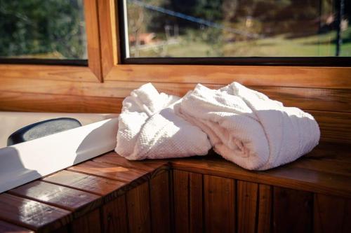 una toalla blanca sentada en una mesa de madera junto a una ventana en Blue Sunset 4, en Urubici