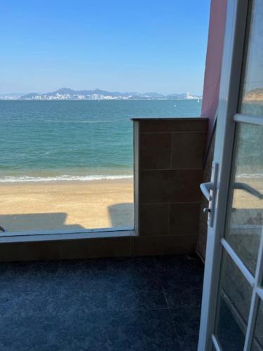 a door to a room with a view of the beach at Sea View Holiday House in Hong Kong