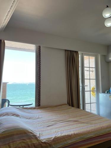 a bedroom with a bed and a large window at Sea View Holiday House in Hong Kong