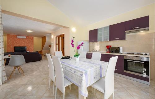kuchnia i jadalnia ze stołem i krzesłami w obiekcie Three-Bedroom Holiday Home In Tinjan w mieście Tinjan