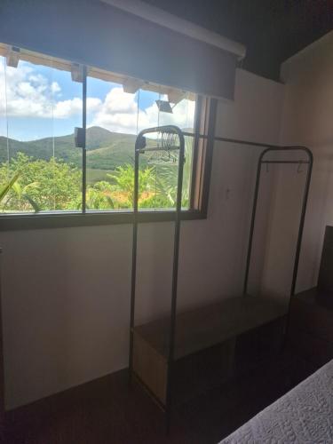 a bedroom with a bed and a window with a view at Max Suíte in Capitólio