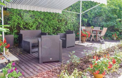 une terrasse en bois avec une table, des chaises et un parasol dans l'établissement Cozy Home In Sahurs With Wifi, à Sahurs