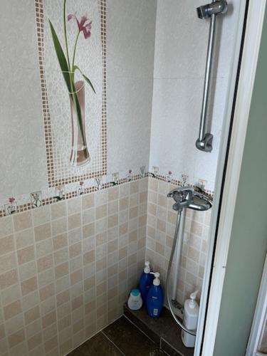 a bathroom with a shower with a vase with a flower in it at Sea View Holiday House in Hong Kong