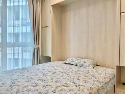 a bedroom with a bed and a window at Olympus City Garden 1 Bedroom in Pattaya South
