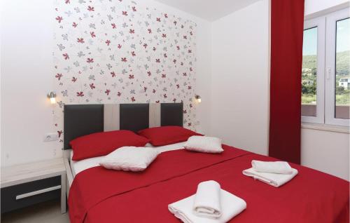 a red bed with red and white towels on it at Amazing Home In Kastel Stafilic in Plano