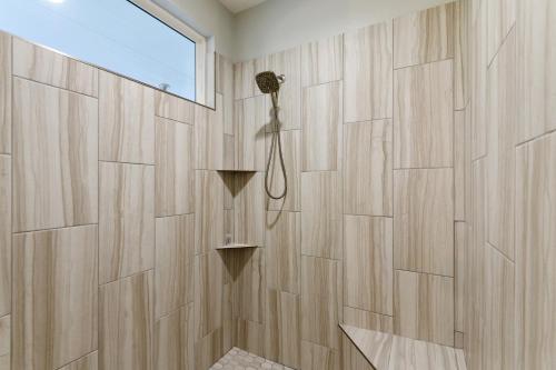 La salle de bains est pourvue d'un mur en bois et d'une fenêtre. dans l'établissement 3 Mi to Lake Cabin with Hot Tub in Broken Bow!, à Stephens Gap