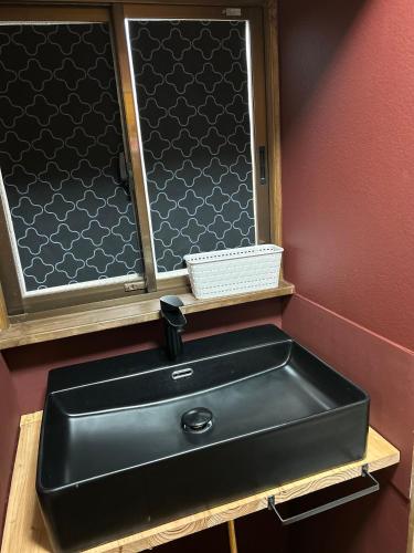 a black sink in a bathroom with a mirror at ポートサイドSasebo藤原町 in Sasebo