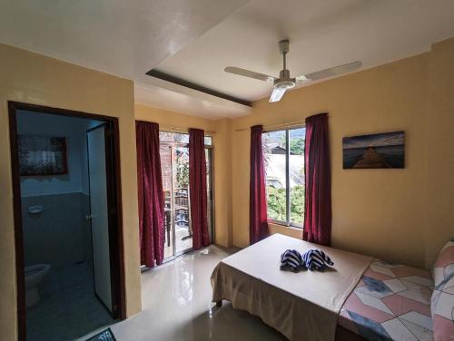 a bedroom with a bed with two pairs of shoes on it at Francis Dale Lodge L3 in El Nido