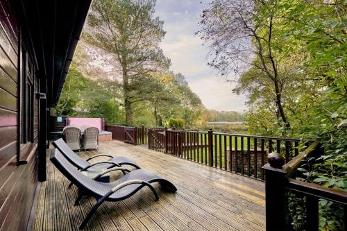 a porch with a bench on a deck with a view at Dunnock Lodge with Hot-tub in Carlisle