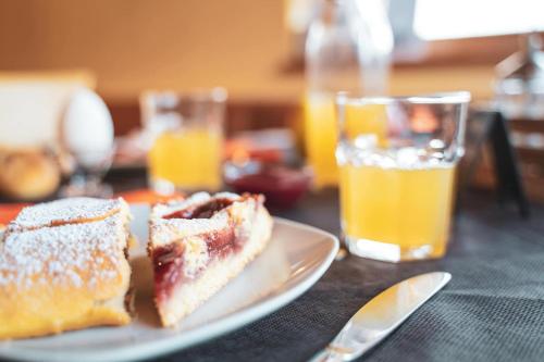 un plato con dos piezas de comida y un vaso de jugo de naranja en Villa Martina luxury suites, en Lecco
