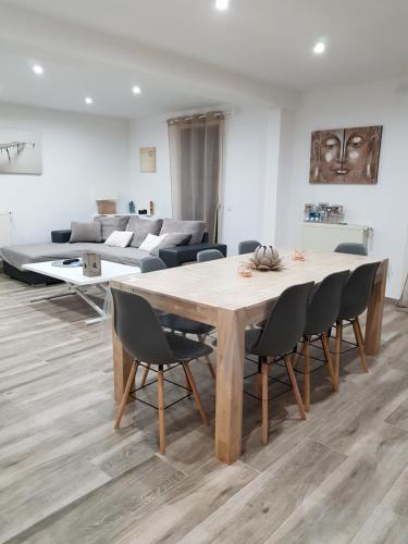 un salon avec une table, des chaises et un canapé dans l'établissement Appartement F4 à 8 min à pieds de la mer, à Canet
