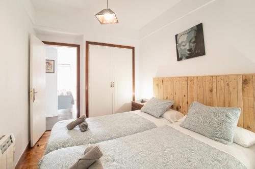 ein Schlafzimmer mit zwei Betten und einem Fenster in der Unterkunft Apartment Amara AMONAREN ETXEA Free WiFi, ROOMS, rent parking in San Sebastián