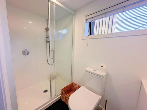 a white bathroom with a toilet and a shower at Lake view retreat Studio in Queenstown