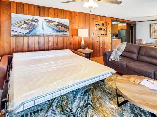 a bedroom with a large bed and a couch at Grassy Knoll Retreat on the Big Spirit Lake in Orleans