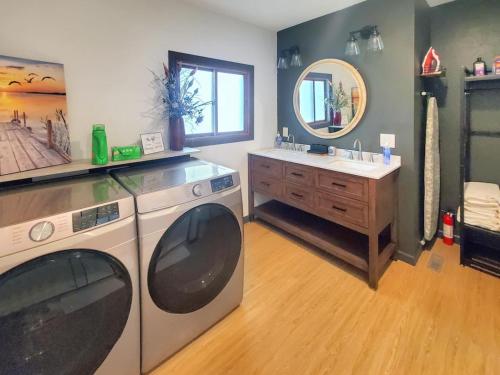 a bathroom with a washing machine and a sink at Grassy Knoll Retreat on the Big Spirit Lake in Orleans