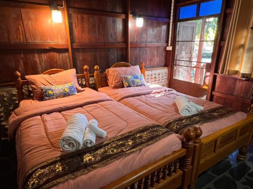 a bedroom with a large bed with two pillows at Riverside Retreat Sukhothai Guest House in Sukhothai