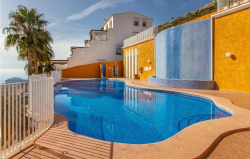 a swimming pool next to a building at Cozy Apartment In Cumbre Del Sol in Cumbre del Sol
