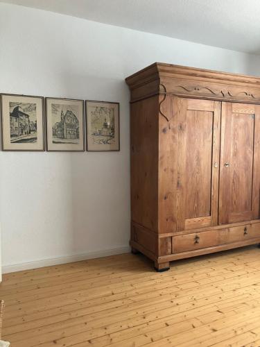 a room with a wooden cabinet and three pictures on the wall at Wohnen auf Zeit in Wittlich