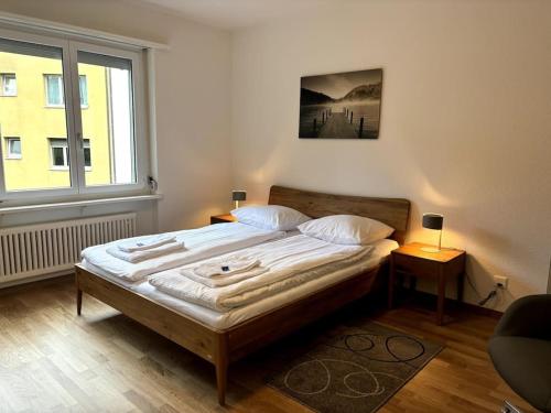 a bed in a room with a large window at Cozy 2BR near Lake - Wille 8 in Zürich