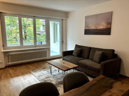 a living room with a couch and a table at Cozy 2BR near Lake - Wille 8 in Zürich