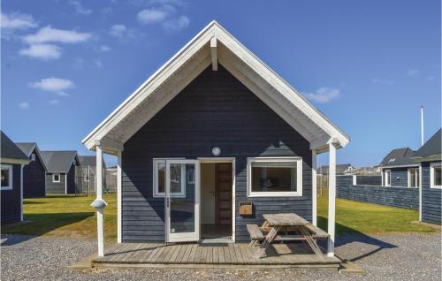 a small blue house with a picnic table and a bench at Hytte 14 in Thyborøn